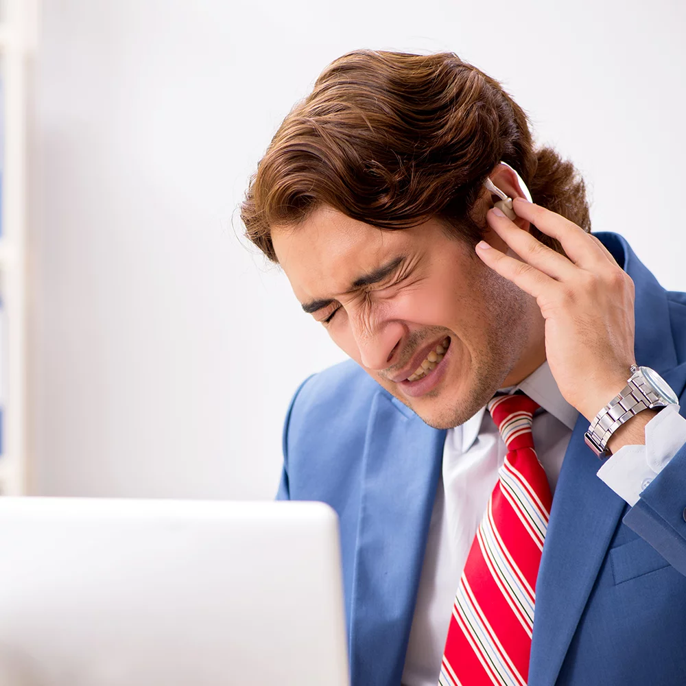 Middle aged man wearing hearing aids and suffering from earache