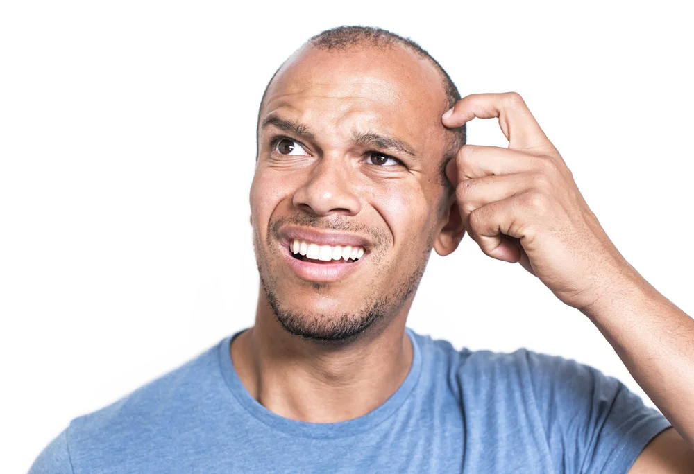 Young male wearing blue shirt scratching head in confusion