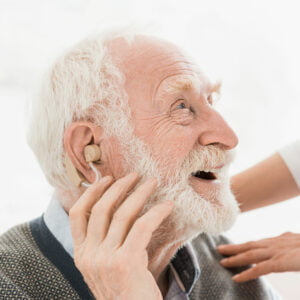 Cheerful-looking senior man with hearing aid in ear