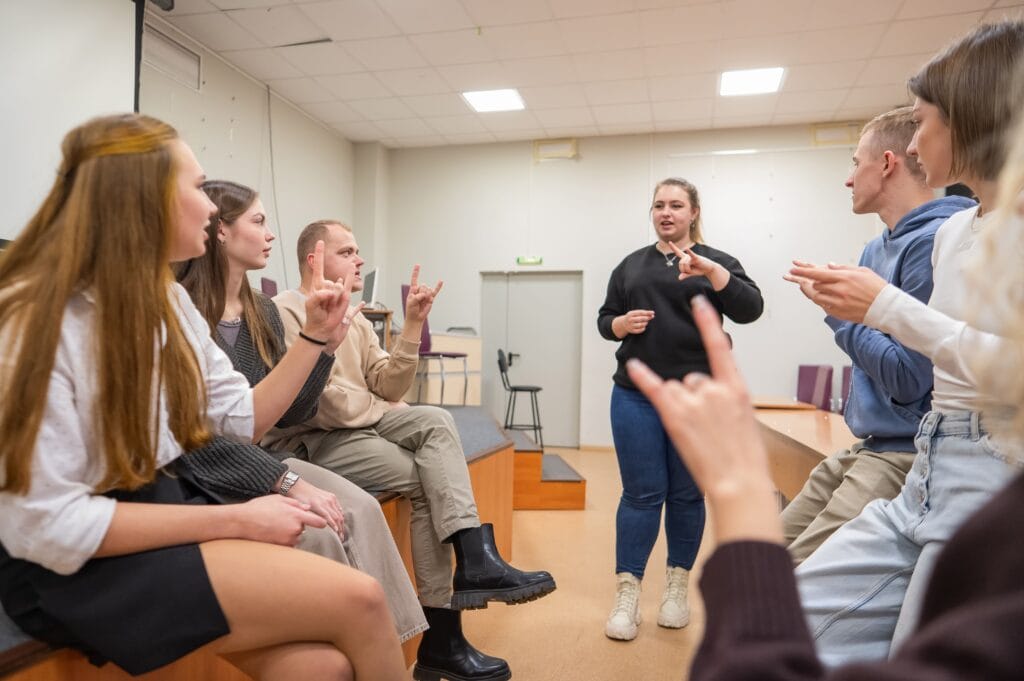 People from deaf culture learning sign language.