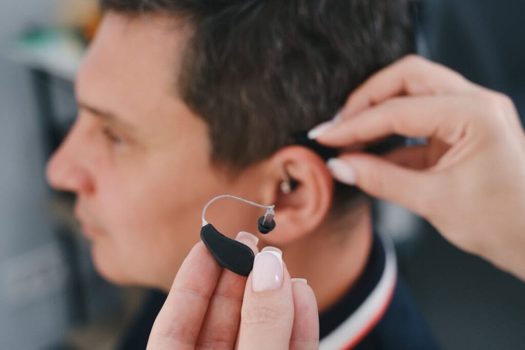 A man getting his rechargeable hearing aids fixed.