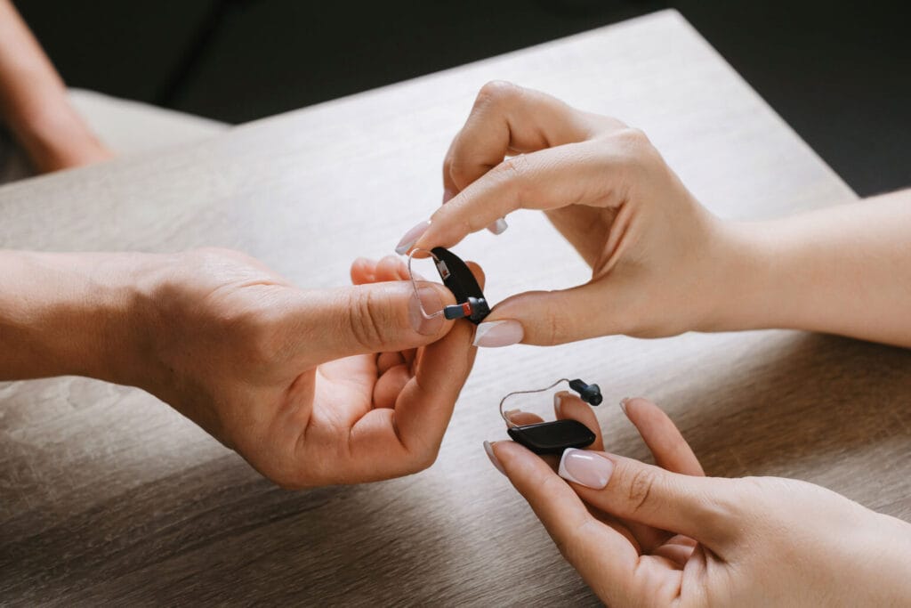 2 hands exchanging hearing aids
